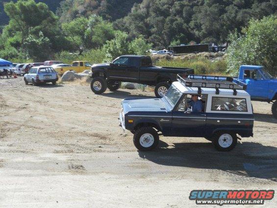 Dark blue 1986 Ford Bronco with white roof and roof rack, 3q-front view