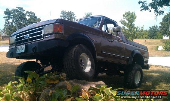 Brown 1987 Ford Bronco with lifted suspension and aftermarket bumper
