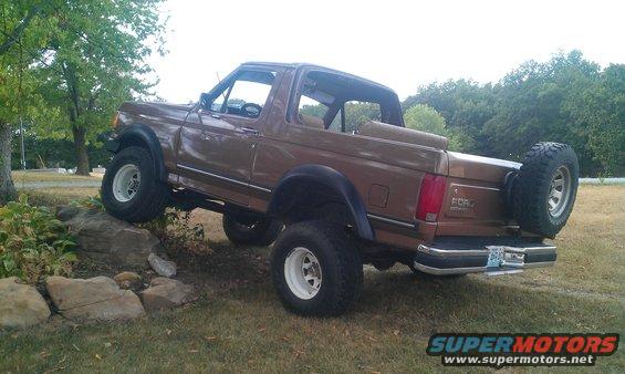 Brown 1987 Ford Bronco climbing over rocks