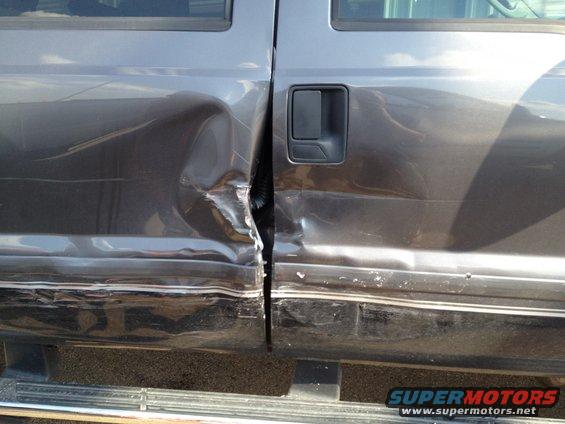 Damaged gray truck doors with significant denting and misalignment
