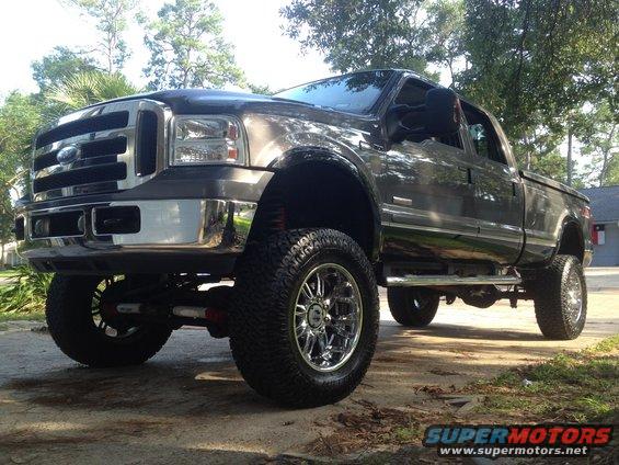 Dark gray lifted Ford F-350 Super Duty pickup truck with chrome wheels and side steps