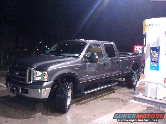 Gray Ford F-350 Super Duty pickup truck at a gas station, driver's side front 3/4 view