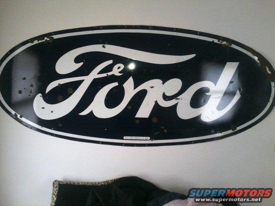 Oval Ford logo sign, black with white script lettering. Some rust spots and wear