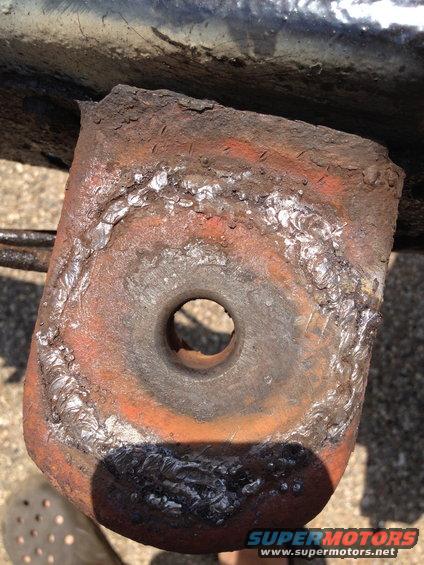 Heavily rusted metal bracket with visible weld marks and a central hole