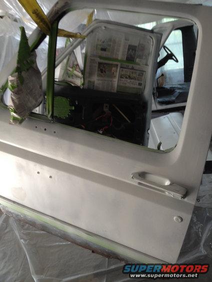 1986 Ford Bronco interior with door open, dashboard covered in newspaper for painting