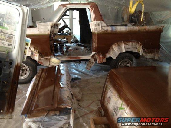 1986 Ford Bronco in garage, masked for paint. Side view shows brown paint and interior