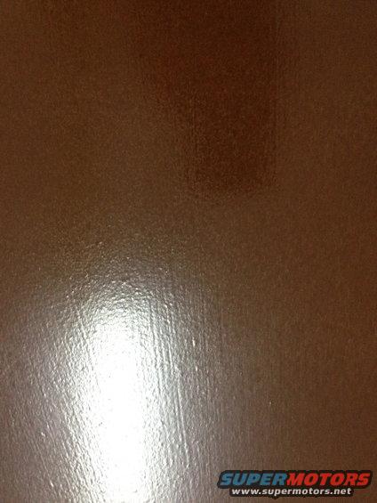 Brown textured surface with light reflection and SUPERMOTORS.NET watermark