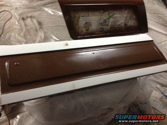 Brown and white tailgate and window frame, possibly for a Ford Bronco, covered in plastic sheeting
