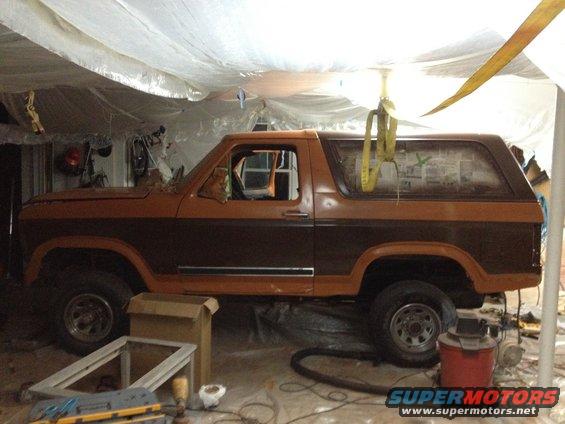 Two-tone brown SUV side view, under tarp. Appears to be from the early 1980s