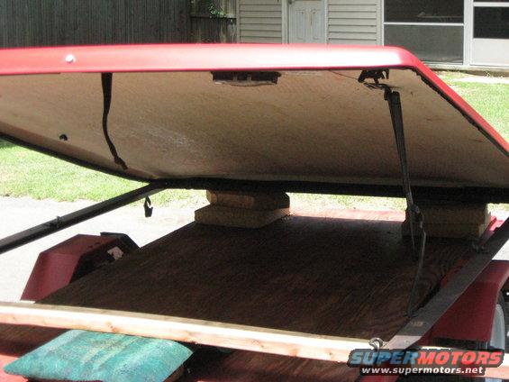 Trailer with red lid open, showing wooden deck and support blocks