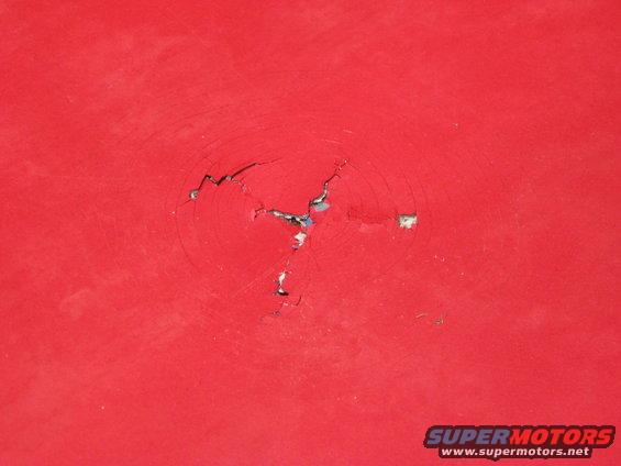 Red painted surface with cracked impact damage