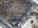 1978 Nissan 300ZX - Close-up view of a heavily rusted floor pan, showing debris and structural bracing.