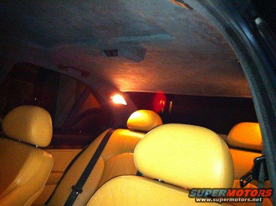 Interior view of car seats and headliner with interior lights on