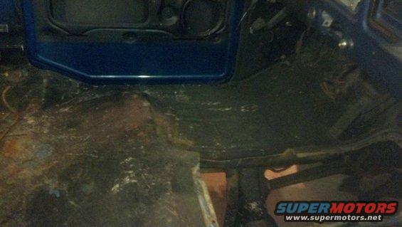Blue vehicle interior floor with rust and debris