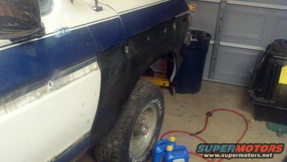 1978 Ford Bronco rear fender area undergoing repair, showing primer and body filler