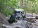 1967 Ford Mustang - A custom off-road buggy is seen traversing a challenging rocky path in a wooded area.