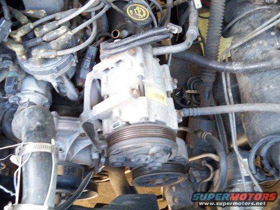 Engine compartment with hoses, wires, and metal parts covered in grime and debris