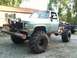 1983 Chevrolet C/K Pickup - A heavily modified pickup truck with large tires and a custom bumper sits in a gravel lot.