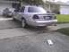 2003 Ford Crown Victoria - Rear view of a silver 2003 Ford Crown Victoria with tinted taillights and aftermarket wheels.