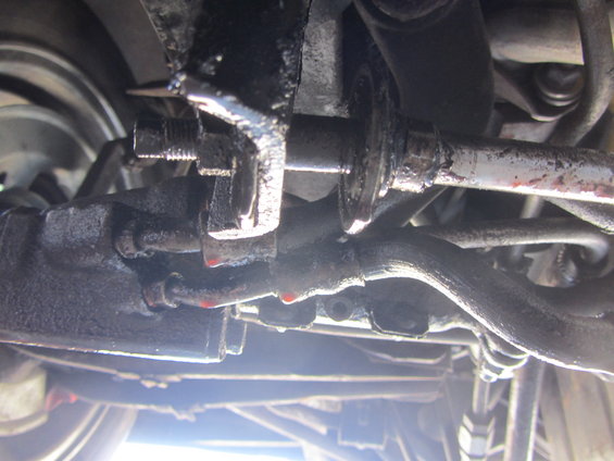 Close-up of greasy steering rack and tie rod ends, with some red fluid drips