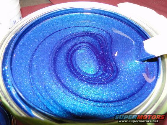 Can of blue metallic paint with swirls from mixing