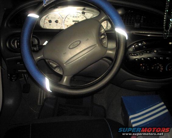1997 Ford Taurus interior with blue steering wheel cover and dashboard gauges