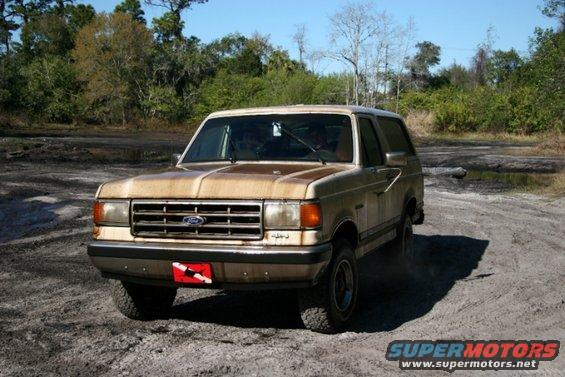 Tan 1987 Ford Bronco parked on a dirt road