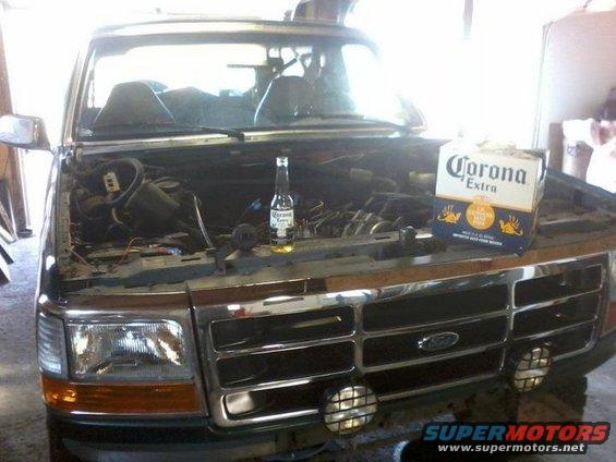 1993 Ford Bronco front view, hood open, with a bottle and box of Corona beer on the engine