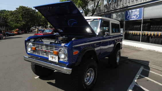 Blue Ford Bronco with hood open, parked outside a Westlie Ford dealership