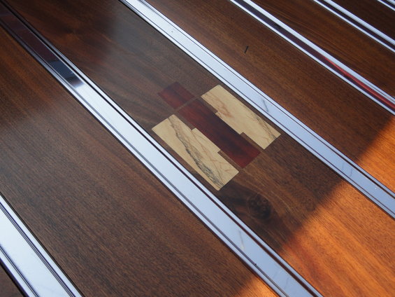 Wood paneling with metal trim and a central wood mosaic red and tan pieces