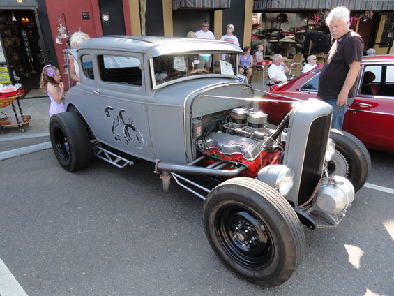 Gray hot rod with exposed V8 engine and flame decals on the side