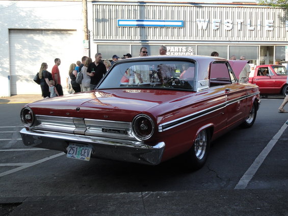 Red 1964 Ford Fairlane coupe, 3q-front view. Chrome trim and side molding visible