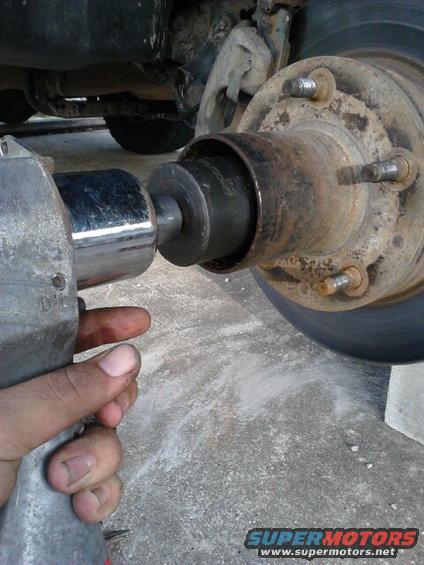 Use a 4 prong spindle nut socket to get the first spindle nut off. my threads on my spindle are damaged so i used an impact wrench to zip it off quickly.