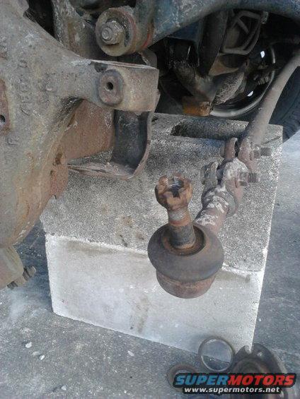Take the Tie Rod End off the knuckle.

Best way is take the nut off and put it back on upside down so the nut is flush with the top of the threads. use a hammer and tap it down till it breakes free. This prevents damageing the threads. Then take the nut off and move it aside.