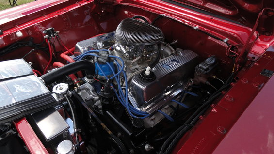 Close-up of a Ford 351 Windsor engine with chrome valve covers and blue spark plug wires