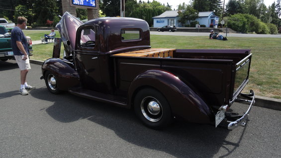 Maroon pickup truck with wood bed and hood open