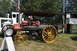 1959 Kenworth W900A - A vintage steam tractor, identified as a Russell, is displayed next to a modern white tractor at an outdoor event.