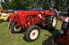 1959 Kenworth W900A - A red Porsche Diesel tractor is parked on grass with other farm equipment.