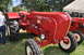 1959 Kenworth W900A - A bright red Porsche Diesel Master tractor is displayed at an outdoor event, with another similar tractor visible behind it.