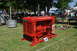 1959 Kenworth W900A - A bright red International UD 16 diesel engine is displayed on a grassy field with tents and people in the background.