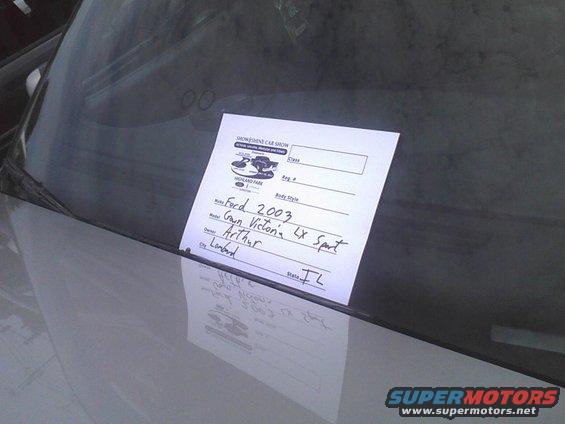 Car show sign on windshield lists Ford 2003 Crown Victoria LX Sport