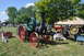1959 Kenworth W900A - A steam traction engine is displayed at an outdoor event with tents and trees in the background.