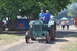 1959 Kenworth W900A - A vintage Hart Parr tractor is driven by two men at an outdoor event.