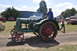 1959 Kenworth W900A - A vintage green tractor with red wheels is seen at an outdoor event with people around.