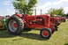 1959 Kenworth W900A - A row of vintage tractors are parked on a grassy field under a partly cloudy sky.