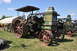 1959 Kenworth W900A - A vintage Rumely tractor is displayed outdoors with other farm equipment under a clear blue sky.