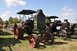 1959 Kenworth W900A - A vintage green tractor with red wheels is parked on grass, with another tractor visible behind it.