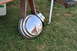 1959 Kenworth W900A - A chrome hubcap with a reflective surface sits on the grass, showing a distorted reflection of a person.