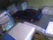 2003 Ford Crown Victoria - A blue coupe is parked in a warehouse surrounded by mattresses.