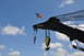 1959 Kenworth W900A - A Bucyrus-Erie crane boom flies an American flag under a partly cloudy sky.